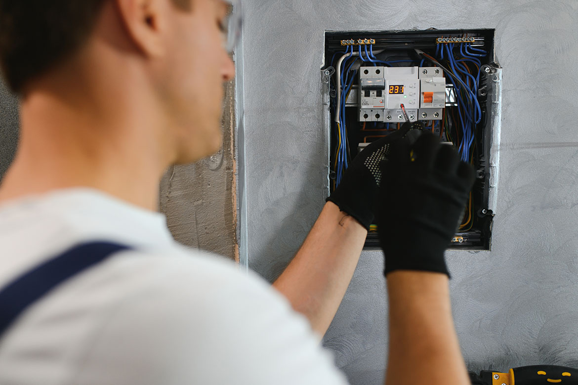 Electrician upgrading a home’s electrical panel with safe, modern wiring solutions.
